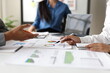 © Wasan - Business people analyzing financial charts and graphs at meeting, discussing company performance and making strategic decisions based on the presented data.