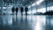 © Thares2020 - Business professionals walking away in a modern industrial building with cars in the background