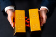 © Volodymyr - Gold bar in hand for invest. Gold and financial invest with gold bar concept. Rich investor and investment deal. Golden bar as a symbol of success invest. Gold for invest and banking purposes.