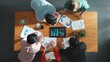© InfiniteFlow - Top down aerial view of business team prepare for meeting and brainstorm marketing idea while planning strategy and looking at investment report or financial graph from tablet. Creative. Convocation.
