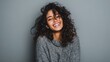 © Johannes - portrait of happy latin young woman isolated on grey wall with copy space carefree hispanic woman smiling and looking at camera standing on gray background beautiful multiethnic girl laughing no logo