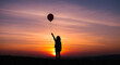 © Олександр Павлов - A child lifts a balloon into the colorful sunset sky.
