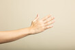 © Pedro - A close-up image of an extended human hand against a neutral beige background. The hand is shown from the side with fingers slightly spread, highlighting the natural skin texture and subtle lighting