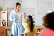 © Home-stock - Professional friendly female teacher giving high five to schoolgirl, after successful exam. Education, childhood, teaching, learning and school concept