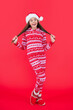 © be free - merry christmas. amazed teen girl in red christmas santa hat standing in studio. teen christmas girl