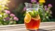 © Audax - Glass pitcher of refreshing iced tea on an outdoor table.
