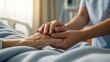 © AudaX - A caregiver or nurse gently holding the hand of an elderly patient in a hospital bed.