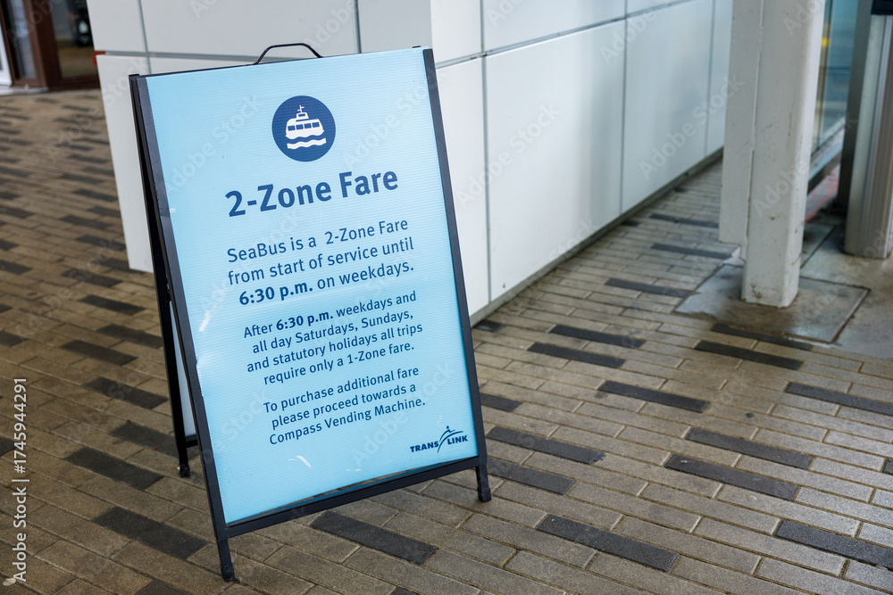 Seabus Sign Blue A-frame sign detailing SeaBus 2-zone fare rules on paved urban ...