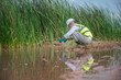 © akarapon - An environmental expert is collecting water samples to check the abundance of natural water sources.