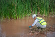 © akarapon - An environmental expert is collecting water samples to check the abundance of natural water sources.