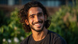 © Dirk - young, handsome middle eastern man in his early to mid-20s with wavy hair and an athletic build stands smiling. wearing a t-shirt and has a relaxed posture. background lush greenery. Attractive young