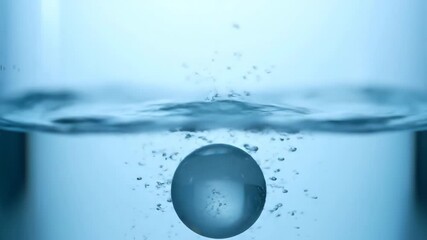 Wall Mural - A smooth glass marble drops into clear water within a glass container, creating elegant ripples in slow motion fluid, glass container, marble