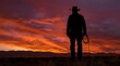 © Rizki - Cowboy silhouette holding rope against dramatic sunset desert sky