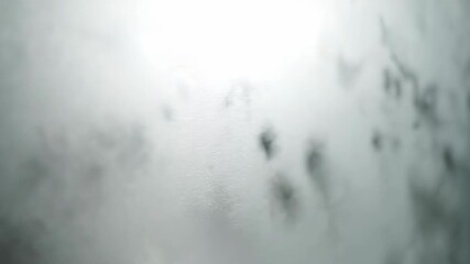 Wall Mural - Close-up slow pan across a frosted glass surface with soft, diffused light creating a textured, elegant, and abstract background concept, meditation, translucence