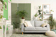 © Pixel-Shot - Interior of stylish living room with grey sofa, shelving units and houseplants
