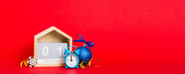 Wall Mural - 1 january. Christmas composition on colored background with a wooden calendar, with a gift box, toys, bauble copy space