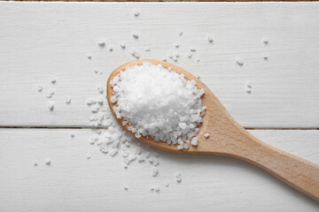Wall Mural - Spoon of sea salt on light wooden background, closeup