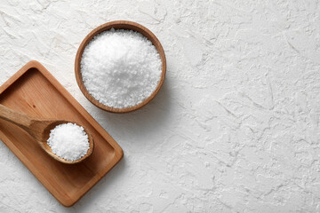 Wall Mural - Wooden bowl of sea salt, spoon and board on light background