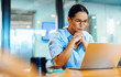 © (JLco) Julia Amaral - Businesswoman focusing intently on her laptop in a professional office setting