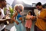 Friends playing cavaquinho and pandeiro while dancing samba in Rio de Janeiro
