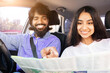 © Anastasiya - Cheerful Indian couple reading map in car, smiling while navigating route. Depicts road trip, travel adventure, teamwork and exploring journey together with joy