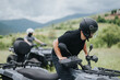 © qunica.com - Two friends ride quad bikes through a beautiful countryside trail wearing helmets for safety.
