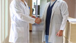 © Alina - Close-up of two doctors shaking hands, favorable treatment prognosis. Medicine concept