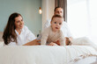 © Doralin - Happy family playing with baby on bed at home
