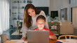© Monkey Business - Mother Helping Son Studying Using Laptop At Home Together