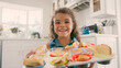 © Monkey Business - Portrait Of Proud Girl In Kitchen Holding Tray Of Homemade Cupcakes