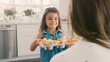 © Monkey Business - Proud Daughter In Kitchen Showing Homemade Cupcakes To Mother