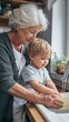© t.sableaux - Grandmother and toddler joyfully washing dishes together in a cozy kitchen, showcasing multigenerational family life and emotional connection