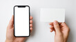 © saichon - Smartphone with blank screen held in one hand and blank card in other, against white background