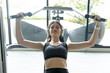 © Ratirat - Confident women working out on chest press machine at gym, wearing wireless headphones and sportswear, symbolizing strength, motivation, and healthy lifestyle.