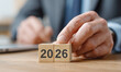 © Samia - Close-up of hand placing a wooden block spelling out 2026. Concept of happy new year.