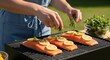 © DAVA - Fresh salmon fillets grilling outdoors, seasoned with herbs and lemon
