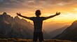 © Igor - a man viewed from behind, standing atop a mountain with his arms wide open, embracing a magnificent sunset