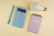 © Maryna - Calculator, pen, light bulb and 2026 planner on beige background symbolizing business planning