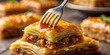 © MH24 - Close up of delicious baklava being lifted by a fork with dripping honey on a wooden surface