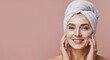 © Cleverson - Woman with facial cream and towel smiling against a soft pink backdrop. Self-care aesthetic.