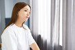 © hidez - Young woman looking out the window in natural light
