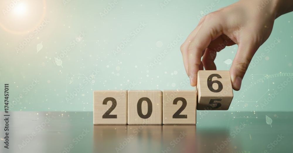 Hand placing a wooden block with number 6 to change year 2025 to 2026 ...