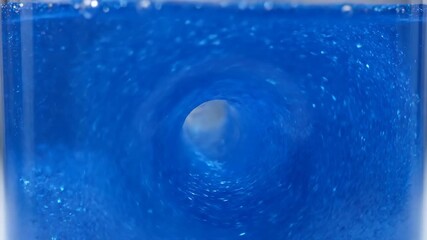 Wall Mural - Hypnotic blue glitter particles swirl and dance in a captivating liquid vortex in a timelapse spiral, movement, mystery
