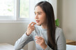 © KMPZZZ - Dietary supplement, healthy diet positive asian young woman hand holding pill capsule, take vitamin in mouth for beauty skin hair, taking medicine with glass of water at home, pharmacy and health care