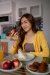 © snowing12 - Asian woman adult enjoys healthy breakfast at home smiling daily routine modern kitchen happy relaxed environment