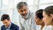 © N7 - Mature Indian team leader guiding project discussion — representing guidance, collaboration, and business growth