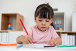 © geargodz - toddler baby girl training to drawing with colored pencil on desk at home