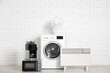 © Pixel-Shot - Different household appliances near white brick wall