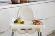 © Pixel-Shot - Baby highchair with puree, broccoli and toy in kitchen, closeup
