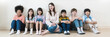 © paulaphoto - Portrait of teacher group of multicultural students sit in classroom, asian caucasian children together in school. Home school education, diversity multicultural community. Back to school banner